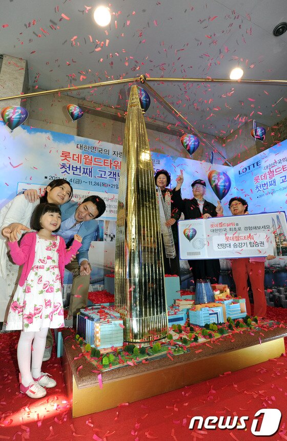 본문 이미지 - 롯데월드타워 전망재는 약 500m 높이에 위치한다. 사진은 롯데백화점이 지난 2011년 롯데월드타워 오픈당일 전망대 승강기 탑승권과 롯데호텔 숙박권을 제공 이벤트를 진행하는 모습..