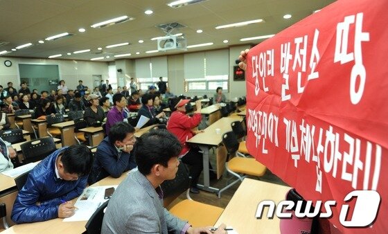 본문 이미지 - 26일 오후 서울 마포구 서강동주민센터에서 열린 서울복합화력발전소 주민설명회에서 신규지하건설반대추진위원회의 한 주민이 서울화력발전소 이전을 촉구하는 피켓을 들고 있다. © News1 이정선 기자