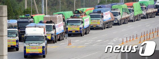 본문 이미지 - 5일 오전 경기 파주시 도라산 남북출입국사무소에서 국내 55개 인도적 대북 지원단체 협의체인 대북협력민간단체협의회(북민협)의 대북 수해지원용 밀가루 500톤을 실은 트럭들이 북녘으로 향하고 있다. 북민협과 민화협은 북한 평안남도의 수재민들을 돕기 위해 1차로 밀가루 500톤(2억 6천만 원 상당)을 개성 육로를 통해 북한에 지원했다. 2012.10.5/뉴스1 © News1 오대일 기자