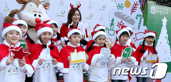 (서울=뉴스1) 김보영  = 29일 오전 서울 명동 눈스퀘어 앞에서 열린 굿네이버스 연말 나눔 캠페인 '희망트리'에서 배우 문정희와 아이들이 희망을 전하는 구호를 외치고 있다. ' …