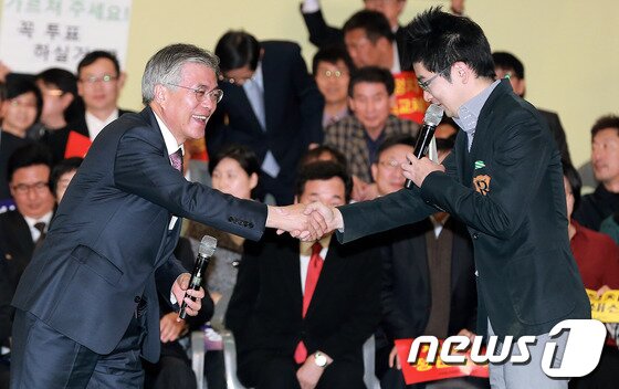 본문 이미지 - 문재인 대통령이 민주통합당 대선후보일 당시인 2012년 11월4일 오후 경기도 고양시 킨텍스 제2전시장에서 열린 중앙·수도권 대통령선거대책위원회 출범식에서 사회를 맡은 탁현민 행정관(당시 교수)와 악수하고 있다.2012.11.04/뉴스1