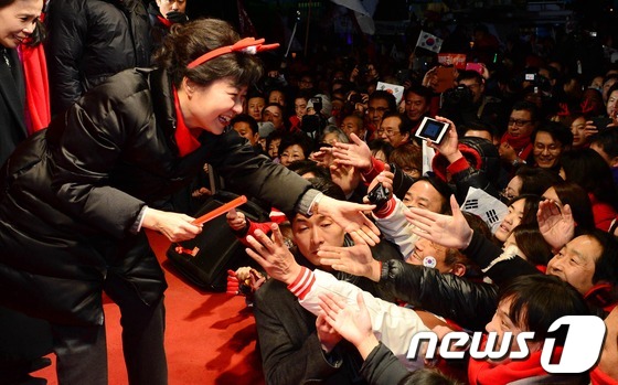 (서울=뉴스1) 이종덕 기자 = 박근혜 새누리당 대통령후보가 대선을 하루 앞둔 18일 서울 광화문광장 유세에서 지지자들과 손을 잡고 있다. 박 후보는 광화문 유세 후 서울 명동,동 …