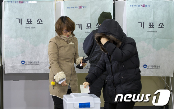 (서울=뉴스1) 이명근 기자 = 제18대 대통령 선거일인 19일 오전 서울 종로 교동초등학교에 마련된 투표소에서 유권자들이 투표개시와 함께 투표를 하고 있다. 2012.12.19/ …