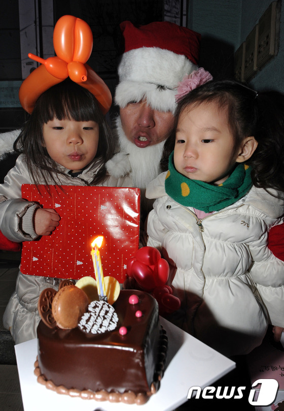 (서울=뉴스1) 박세연 기자 = 성탄절을 앞둔 23일 오후 서울 마포구의 한 가정 앞에서 7년째 몰래산타를 하고 있는 김예창 산타가 어린이들을 찾아와 선물을 전해주고 함께 케이크의 …