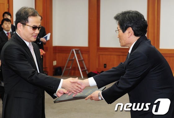 (과천=뉴스1) 이정선 인턴기자 = 12일 오전 경기도 과천 중앙선거관리위원회에서 김능환 위원장이 제 19대 국회의원 민주통합당 최동익 비례대표에게 당선증을 전달하고 있다. 201 …