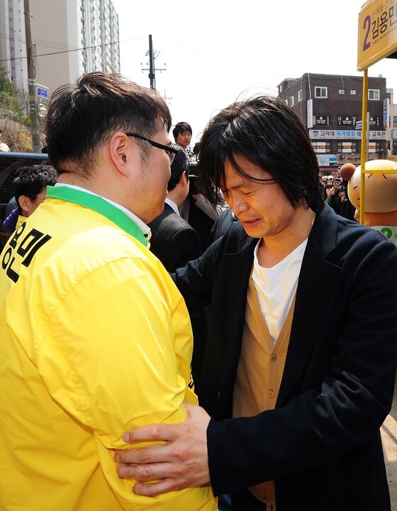 본문 이미지 - 2012년 4.11 총선 마지막 주말 유세에 나선 당시 김용민 민주통합당 노원갑 후보를 주진우 기자가 안으면서 눈물을 보이고 있다. ⓒ News1