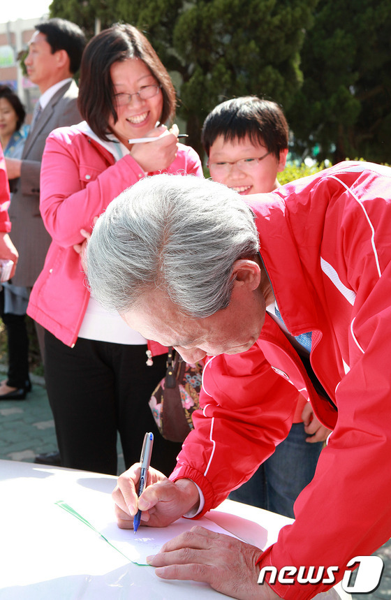 (서울=뉴스1) 박지혜 인턴기자 = 새누리당 강남을 김종훈 후보가 9일 오후 서울 강남구 대치동 은마아파트 주변에서 사인을 하고 있다. (김종훈 후보 사무소 제공)