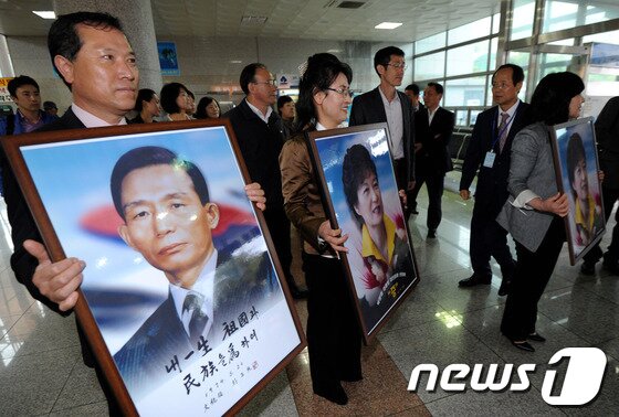 본문 이미지 - 2012년 5월1일  제주시 건입동 연안여객선터미널에서 새누리당 박근혜 비상대책위원장의 지지자들이 박정희 전 대통령과 박 위원장의 사진을 들고 박 위원장을 기다리고 있다. .2012.5.1/뉴스1