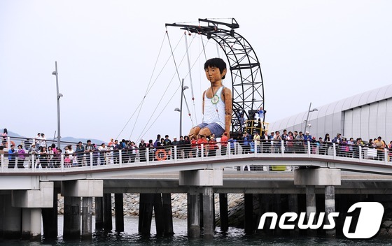 (여수=뉴스1) 박철중 기자 = 2012 여수세계박람회가 열리고 있는 13일 오후 전남 여수시 덕충동 박람회장내 여니교에 대형인형 연안이와 관람객들이 해상쇼를 관람하고 있다.201 …