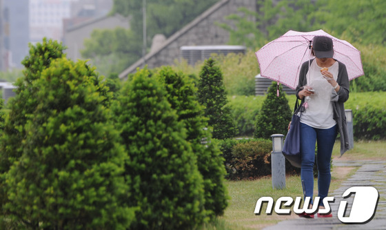 (서울=뉴스1) 양동욱 기자 = 서울을 비롯한 전국 대부분지방에 비가 내리고 있는 14일 오후 서울 서대문구 이화여자대학교 캠퍼스에서 학생들이 우산을 쓰고 교정을 거닐고 있다. 기 …