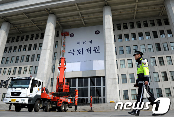 (서울=뉴스1) 박정호 기자 = 19대 국회 개원을 보름 앞둔 16일 오전 서울 여의도 국회의사당 출입구에 국회개원을 경축하는 대형 현수막이 내걸리고 있다. 2012.5.16/뉴스 …