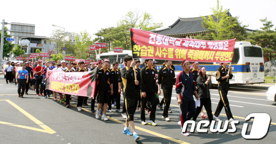 (안동=뉴스1) 피재윤 기자 = 재단의 일방적인 자진 폐교 신청으로 충격을 받은 건동대학교 학생과 교직원 100여명이 18일 경북 안동에서 거리시위를 벌이고 있다.. 이들은 이날 …