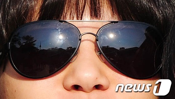 (서울=뉴스1) 이정선 기자 = 태양의 일부를 가리는 부분일식이 진행된 21일 오전 서울 중구 남산 안중근의사 기념관 앞에서 학생들이 선글라스를 낀 채 태양을 관측하고 있다. 20 …