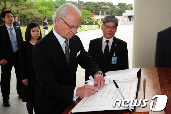 본문 이미지 - 스웨덴 국가원수로는 최초로 국빈 방한중인 칼 구스타프 16세 스웨덴 국왕이 30일 오전 서울 동작동 국립현충원을 찾아 참배하고 방명록에 서명하고 있다. 스웨덴은 6.25 전쟁 당시 UN군에 참여해 야전 병원단을 파견했다. 2012.5.30/뉴스1 © News1   한재호 기자