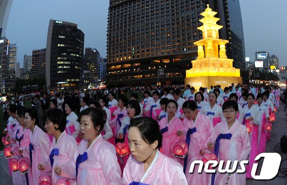본문 이미지 - 부처님오신날을 앞두고 7일 저녁 서울 중구 태평로 서울광장에서 열린 '봉축장엄등 점등식'에서 불자들이 봉축탑을 바라보고 있다. 올해 서울광장에 불을 밝힌 봉축등은 국보 제35호 구례 화엄사 사사자삼층석탑을 원형으로 삼아 전통한지로 제작됐다. 2012.5.7/뉴스1 © News1   박지혜 기자