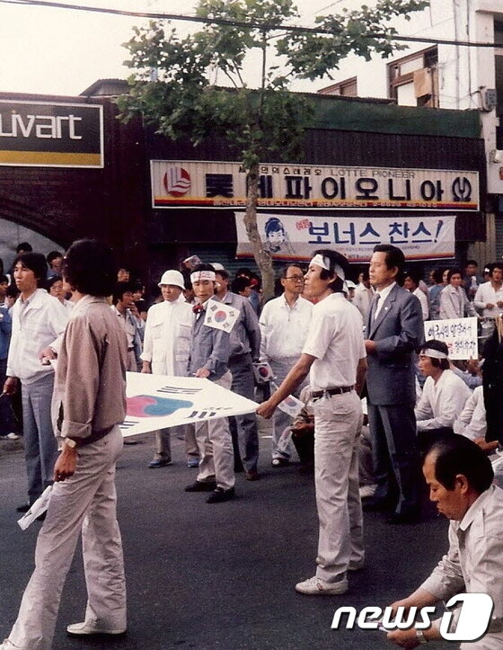 본문 이미지 - 1987년 5월 민주헌법쟁취 울산국민운동본부가 출범한 뒤 첫 거리투쟁에서 심완구 당시 통민당 국회의원(오른쪽 양복)과 한수호 당시 통민당 중앙상무위원(태극기 왼쪽 끝 을 잡고 머리띠한 사람), 재야운동가 장태원(한수호 왼쪽 안경 착용)씨 등이 옥교동에서 '호헌철폐와 독재타도'를 외치며 가두 시위를 벌이고 있다.(사진제공=한수호 울산비전포럼 부회장) News1 © News1 