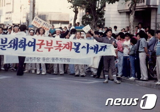 본문 이미지 - 6월 항쟁 당시 중구 옥교동에 당사가 있었던 통일민주당 당원들을 주축으로 한 시위대가 현수막을 들고 가두행진을 벌이고 있다. /사진제공=한수호 울산비전포럼 부회장 © News1 