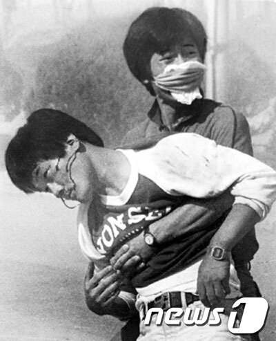 본문 이미지 - 1987년 6월9일 '6·10대회 출정을 위한 연세인 결의대회'시위 도중 전경이 쏜 최루탄을 맞고 쓰러진 이한열 열사의 모습을 당시 로이터 사진기자였던 정태원씨가 촬영한 사진. 이 씨는 이후 사경을 헤매다 그해 7월5일 22살의 젊은 나이로 사망하게 된다. ⓒ News1