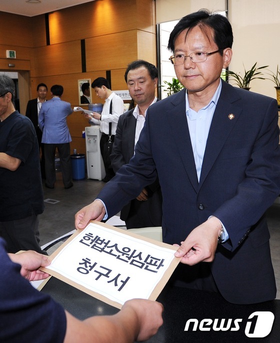 (서울=뉴스1) 박철중 기자 = 금융당국에 대한 헌법소원 청구 기자회견이 열린 16일 오후 서울 북촌로 헌법재판소에서 김기준 민주통합당의원이 헌법소원심판 청구서를 제출하고 있다. …