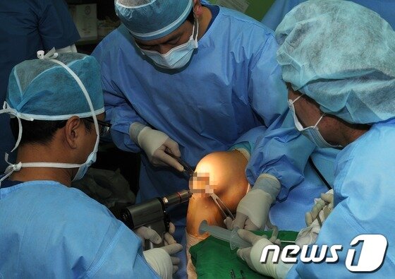 본문 이미지 - 국내 최초 줄기세포치료 공개수술을 실시한 17일 오전 서울 제기동 나은병원에서 집도의 서경원 원장(왼쪽)이 환자의 손상된 무릎을 수술하고 있다. 2012.7.17 ⓒ 뉴스1
