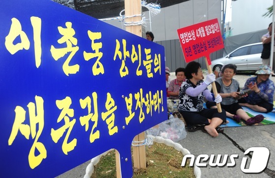 (서울=뉴스1) 손형주 인턴기자 = 30일 오후 서울 용산 이촌동 철도정비창 앞에서 서부이촌동 주민들이 용산 역세권 조속 개발 촉구집회를 열고 있는 가운데 역세권 개발을 찬성하는 …