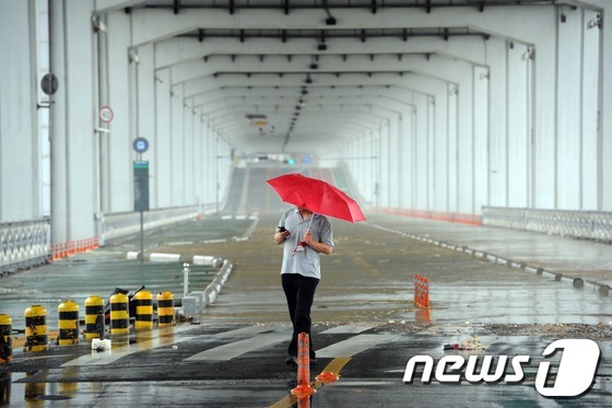 (서울=뉴스1) 허경 기자 = 연일 계속되는 폭우로 한강 물이 불어나며 6일 오전 서울 잠수교 통행이 전면 통제되자 한 시민이 발길을 둘리고 있다. 2012.7.6/뉴스1