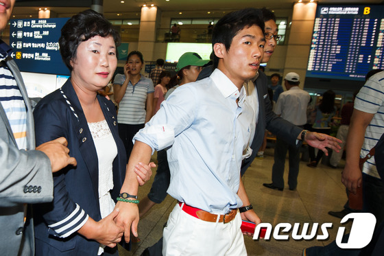 (인천공항=뉴스1) 유승관 기자 = 런던올림픽 남자 체조 도마 금메달리스트 양학선 선수가 11일 오후 인천공항을 통해 귀국해 어머니 기숙향 씨의 손을 잡고 공항을 빠져나가고 있다. …