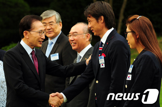 (서울=뉴스1) 오대일 기자 = 이명박 대통령이 16일 청와대 녹지원에서 열린 2012 런던올림픽 선수단 초청 만찬에 참석한 홍명보 올림픽축구대표팀 감독을 격려하고 있다.(청와대 …