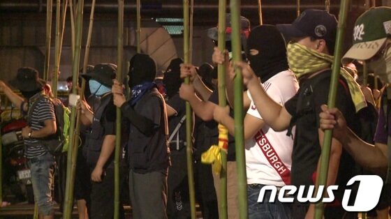 본문 이미지 - 현대차 울산공장 사내하청 일부 노조원들이 20일 1공장 불법 점거를 시도하며 시위용 만장기에서 깃발을 떼어낸 죽창을 들고있다. / 사진제공=현대자동차 © News1 