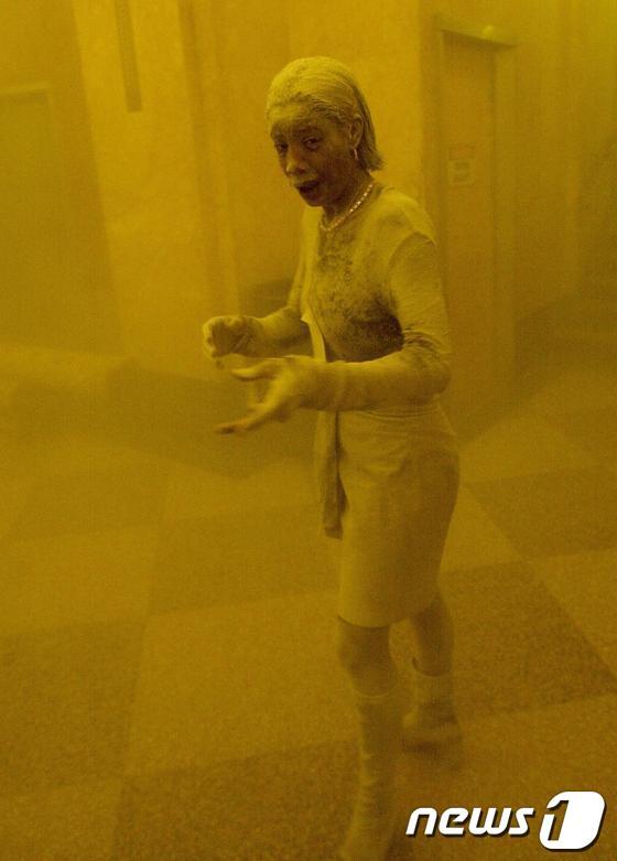 본문 이미지 - WTC 건물 중 한 곳에 갇힌 한 여성의 온 몸이 먼지로 뒤덮였다.©AFP=News1 