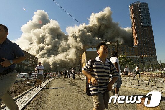 본문 이미지 - 9.11 테러로 놀란 한 시민이 울부짖으며 황급히 자리를 떠나고 있다. ©AFP=News1 