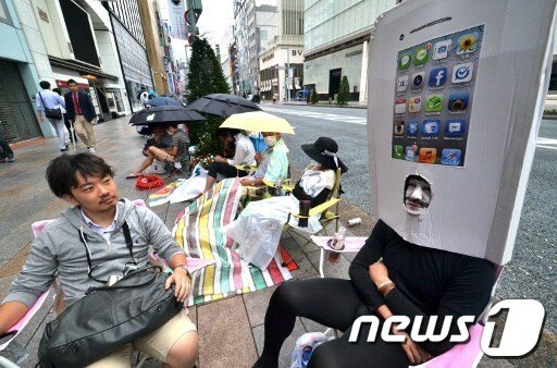 본문 이미지 - 소비자들이 21일 일본 도쿄에 위치한 소프트뱅크 모바일 핸드폰 매장 앞에서 아이폰5를 구입하기 위해 준비한 의자에 앉아 기다리고 있다. © News1