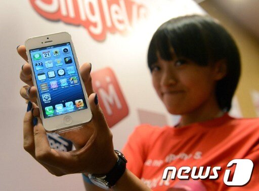 본문 이미지 - 21일 싱가포르에서 가장 먼저 아이폰5를 구입한 리우 팅 팅이 구입한 제품을 보여주고 있다. © AFP=News1 