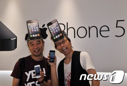 본문 이미지 - 21일 도쿄에서 아이폰5를 구입한 고객들이 아이폰 종이모형으로 만든 머리띠를 두른채 사진포즈를 취하고 있다. © AFP=News1 