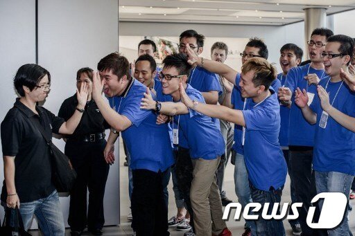 본문 이미지 - 21일 홍콩에서 아이폰5를 구입한 고객을 향해 매장 직원들이 하이파이드 인사를 하며 축하하고 있다. © News1 