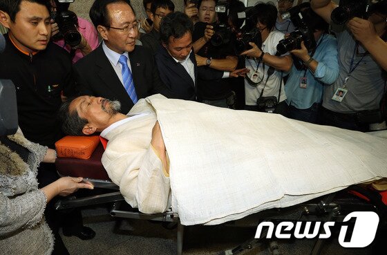 본문 이미지 - 2012년 9월 7일 단식5일째를 맞은 통합진보당 강기갑 대표가 서울 여의도 국회의사당 의정지원단에서 들것에 실려 병원으로 호송되고 있다. 2012.9.7/뉴스1 ⓒ 뉴스1 DB