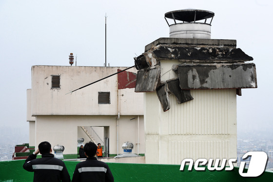 (전주=뉴스1) 김대웅 기자 = 22일 오후 1시경 전북 전주시 진북동 우성아파트 117동 건물 옥상에 설치된 굴뚝이 무너져 아슬아슬하게 걸려 있다. 2013.01.22/뉴스1