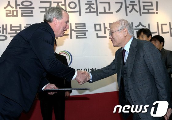 김용준 대통령직 인수위원장이 8일 오후 서울 종로구 삼청동 인수위 별관 로비에서 열린 국민대통합위원회 임명장 수여식에서 인요한 부위원장에게 임명장을 전달하고 있다. 2013.1.8/뉴스1