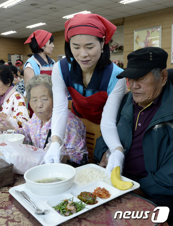 (서울=뉴스1) 안은나 기자 = 제17회 노인의 날인 2일 오전 서울 중랑노인복지관에서 열린 아름다운 어르신 대축제에서 자원봉사자들이 어르신들께 특식을 가져다 드리고 있다. 201 …