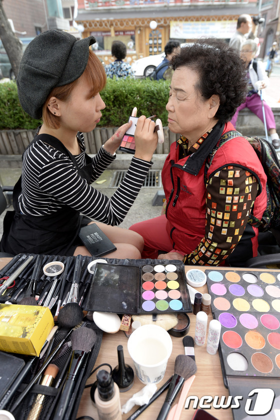 (서울=뉴스1) 안은나 기자 = 제17회 노인의 날인 2일 오전 서울 중랑노인복지관에서 열린 아름다운 어르신 대축제에서 한 어르신이 메이크업을 받고 있다. 2013.10.2/뉴스1 …