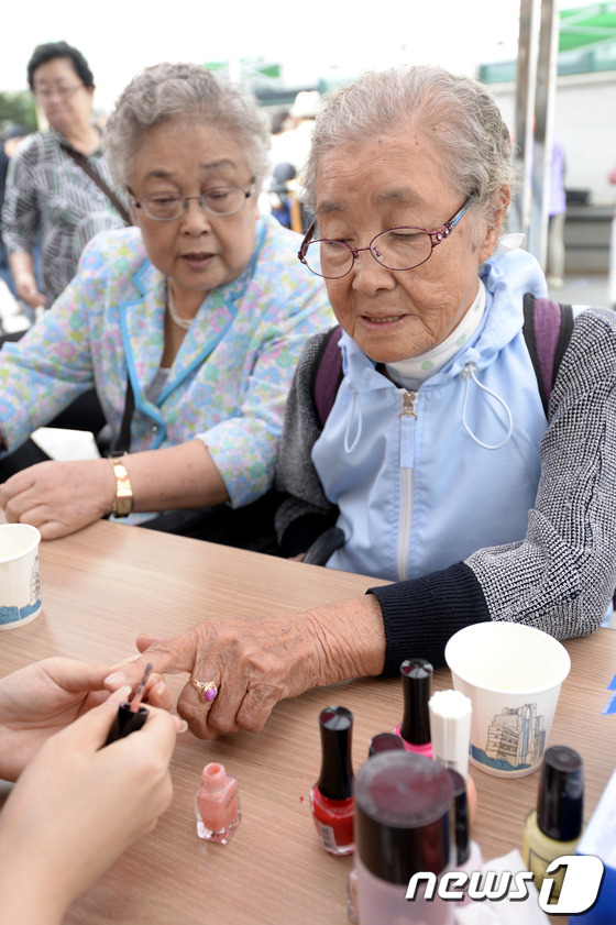 (서울=뉴스1) 안은나 기자 = 제17회 노인의 날인 2일 오전 서울 중랑노인복지관에서 열린 아름다운 어르신 대축제에서 어르신들이 네일아트를 받고 있다. 2013.10.2/뉴스1