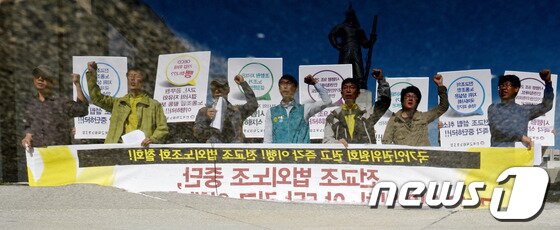 본문 이미지 - 전국교직원노동조합 회원들이 23일 오전 서울 광화문 광장에서 전교조 법외노조 중단 촉구 기자회견을 열고 구호를 외치는 모습이 물에 비치고 있다. 2013.10.23/뉴스1