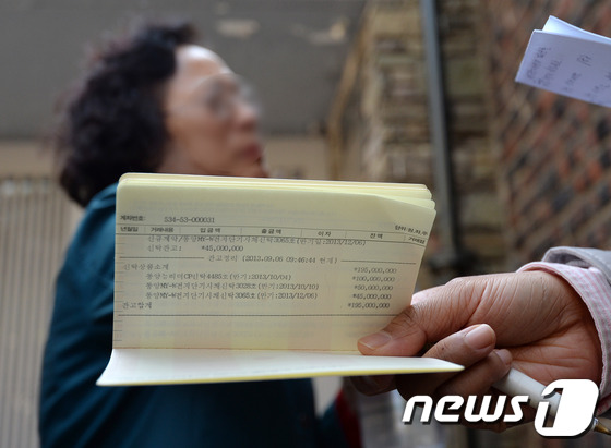 (서울=뉴스1) 박지혜 기자 = 25일 오후 서울 성북구 현재현 회장 자택 앞에서 열린 동양증권 회사채 투자자 피해보상 요구집회에서 한 동양사태 피해자가 억울함을 호소하고 있다.이 …