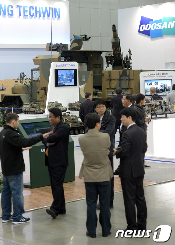 (서울=뉴스1) 손형주 기자 = 28일 경기도 고양시 킨텍스에서 열린 서울 국제 항공우주 및 방위산업 전시회(서울ADEX) 전시회장에서 관람객들이 105mm 차륜형 자주포를 관람하 …