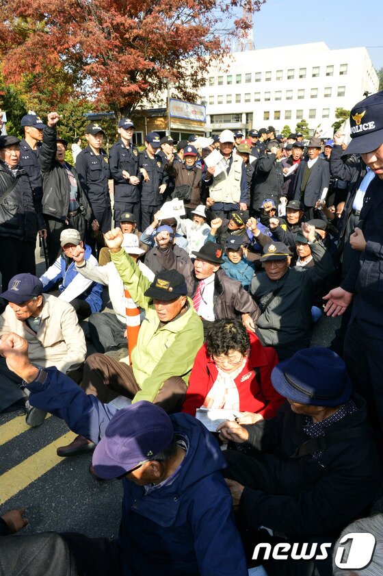 본문 이미지 - 대한민국어버이연합 등 보수단체 회원들이 31일 오후 수원시 영통구 수원지방법원 입구 앞에서 차량출입을 막은 채 이석기 통합진보당 의원의 내란음모사건에 대한 처벌을 요구하며 구호를 외치고 있다. © News1 최영호 기자