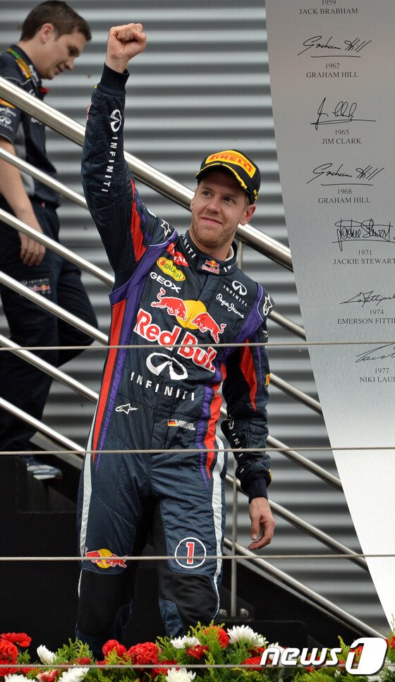 본문 이미지 - 6일 오후 전남 영암 코리아인터내셔널 서킷에서 열린 F1 코리아 그랑프리 결선경기에서 1위를 차지한 세바스찬 베텔이 시상대에 오르며 환호하고 있다. 2013.10.6/뉴스1 © News1   박세연 기자