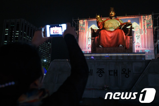 (서울=뉴스1) 유승관 기자 = 8일 오후 서울 광화문 광장에서 열린 '2013 한글문화큰잔치의 밤' 행사에 참석한 시민이 3D입체영상이 투사된 세종대왕 동상을 촬영하고 있다.23 …