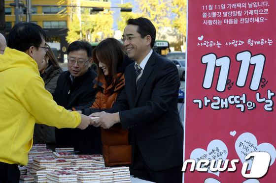 (서울=뉴스1) 안은나 기자 = 11일 오전 서울 종로구 동화면세점 앞에서 열린 '가래떡의 날' 행사에서 농협 직원들이 시민들에게 가래떡을 나눠주며 쌀소비 촉진을 홍보하고 있다. …