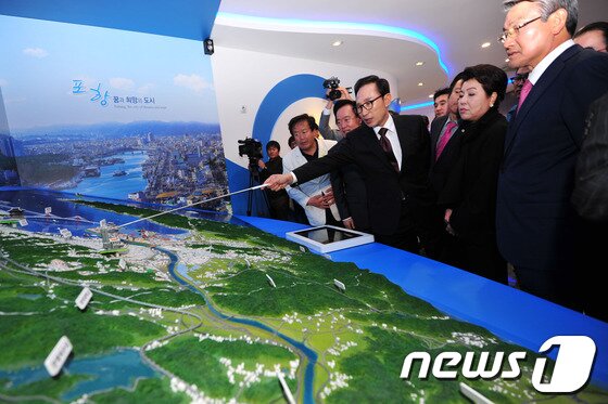 본문 이미지 - 이명박 전 대통령이 부인 김윤옥 여사와 함께 마지막 방문지인 포항운하를 찾아 박승호 시장에게 공사현황에 대해 질문하고 있다.2013.11.13/뉴스1  2013.11.13/뉴스1 © News1   최창호 기자