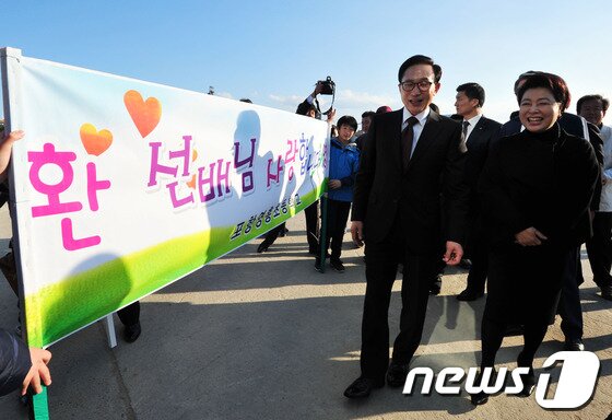 본문 이미지 - 포항운하를 찾은 이 대통령이 모교인 영흥초등학교 후배들로부터 환영을 받으며 운하관으로 입장하고 있다. 이에 앞서 이 대통령 내외는 고향마을인 북구 흥해읍 덕실마을과 선영을 찾아 친지들과 인사를 나눴다.2013.11.13/뉴스1 © News1   최창호 기자